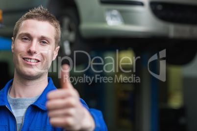 Smart car mechanic gesturing thumbs up