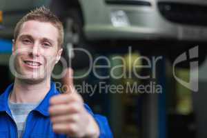 Smart car mechanic gesturing thumbs up
