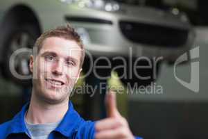 Car mechanic gesturing thumbs up