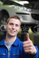 Handsome car mechanic gesturing thumbs up