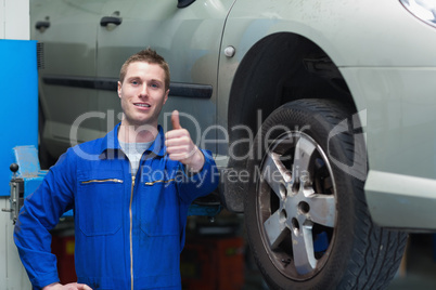 Mechanic by car gesturing thumbs up