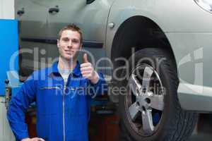 Mechanic by car gesturing thumbs up