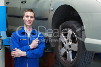 Male mechanic standing by car