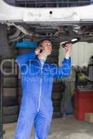 Mechanic on call as he examines car