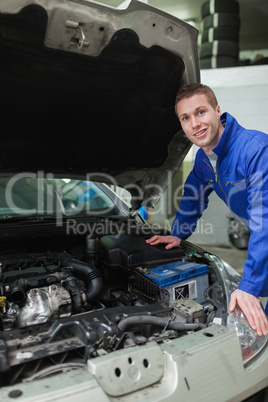 Happy mechanic repairing  car engine