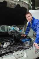 Happy mechanic repairing  car engine
