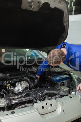 Mechanic working under bonnet of car