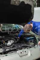 Mechanic working under bonnet of car
