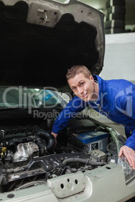 Mechanic working under bonnet of car