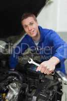 Mechanic with spanner repairing car