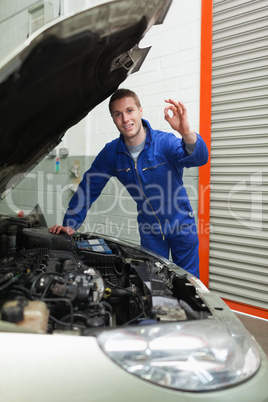 Mechanic by car making ok sign