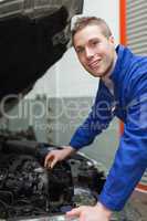 Auto mechanic checking car engine oil