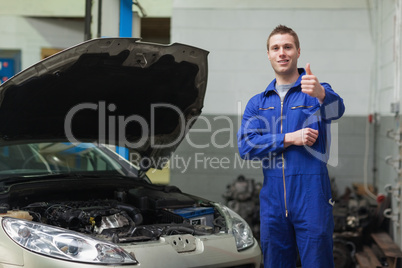 Mechanic by car giving thumbs up gesture