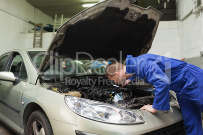 Mechanic working under car bonnet