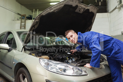 Mechanic examining car engine