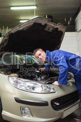 Auto mechanic examining car engine