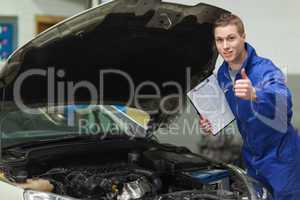 Mechanic with clipboard gesturing thumbs up