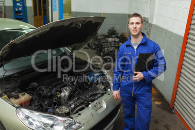Mechanic standing by car with open hood