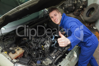 Car mechanic gesturing thumbs up