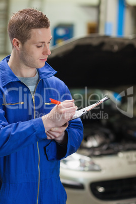 Auto mechanic writing on clipboard