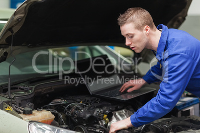 Car mechanic with laptop