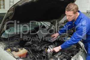 Mechanic with laptop repairing car