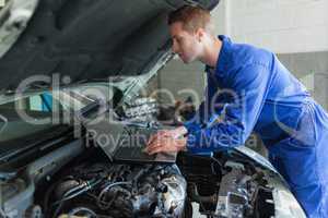 Auto mechanic working on laptop