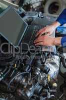 Car mechanic using laptop