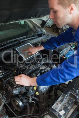 Mechanic with tablet pc repairing car