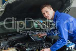 Confident mechanic using digital tablet