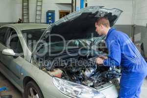 Mechanic analyzing car engine