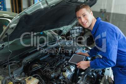 Auto mechanic by car with tablet pc