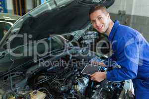 Auto mechanic by car with tablet pc