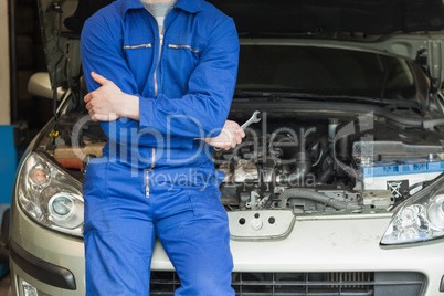 Mechanic leaning on car with open hood