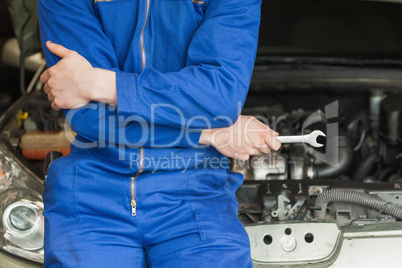 Mechanic leaning on car