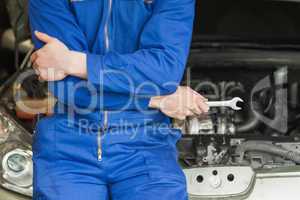 Mechanic leaning on car