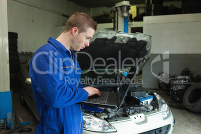 Male mechanic using laptop