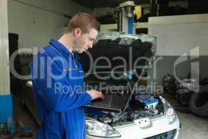 Male mechanic using laptop