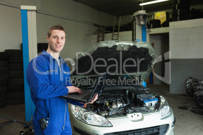 Repairman using laptop in workshop