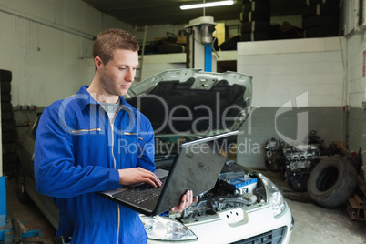 Mechanic using laptop in garage