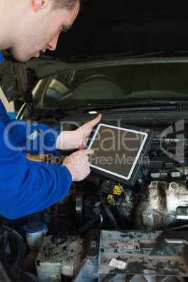 Auto mechanic by car using tablet pc