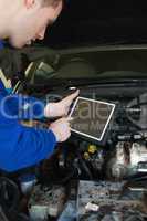 Auto mechanic by car using tablet pc
