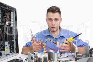 Portrait of young computer engineer working on cpu parts
