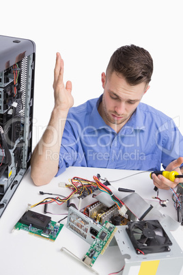 Confused young computer engineer fixing computer parts