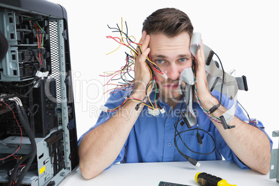 Portrait of tired it professional with cables in hands