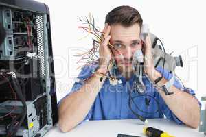 Portrait of tired it professional with cables in hands