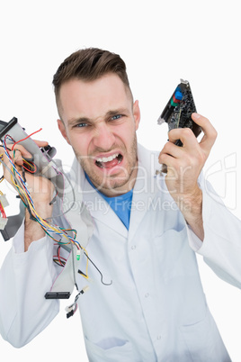 Portrait of young it professional yelling with cpu parts in hand