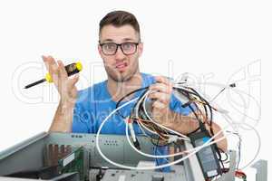 Portrait of confused it professional with screw driver and cable