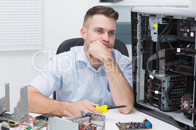 Thoughtful hardware professional sitting by an open cpu