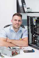 Smiling hardware professional sitting by an open cpu